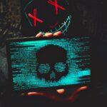 Cybersecurity concept showing masked hacker and code display