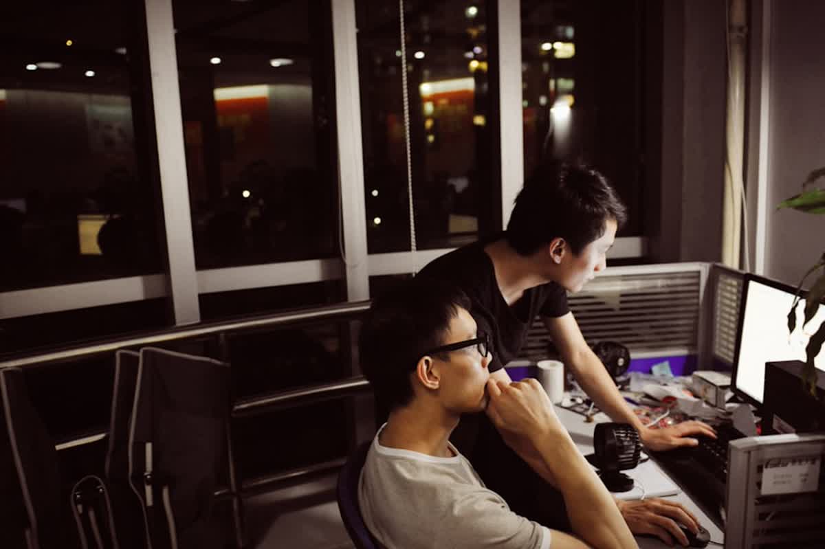 After-Hours IT Support Expectations for Orange County Businesses illustration of Two men working on computers at night