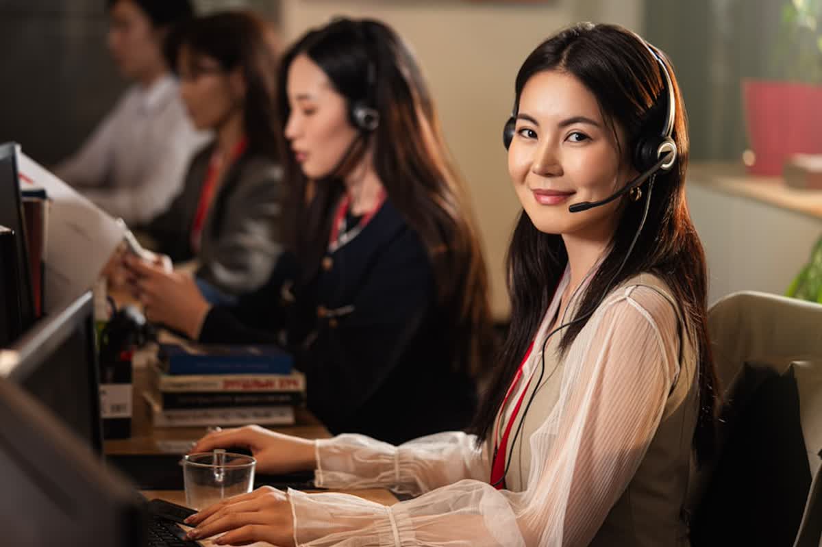 IT Support Response Time Checklist for Orange County Offices illustration of A smiling woman wearing a headset at a computer
