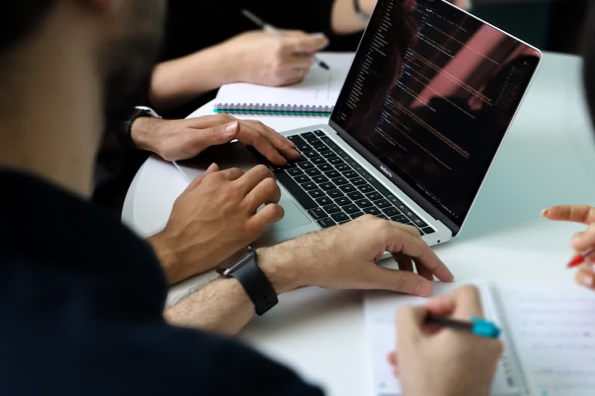 Managed IT RFP Questions for Orange County Businesses illustration of a group of people sitting around a laptop computer