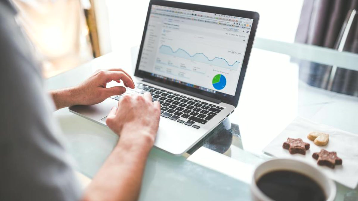 Orange County business manager reviewing key details in laptop performance charts while checklist planning a network refresh budget