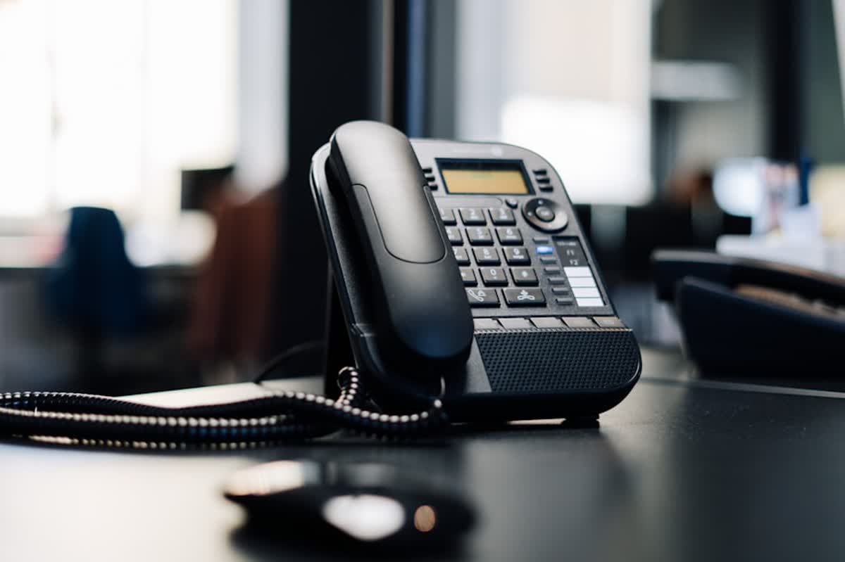 VoIP Failover Plan for Riverside Offices During Internet Outages illustration of black ip desk phone on black wooden table